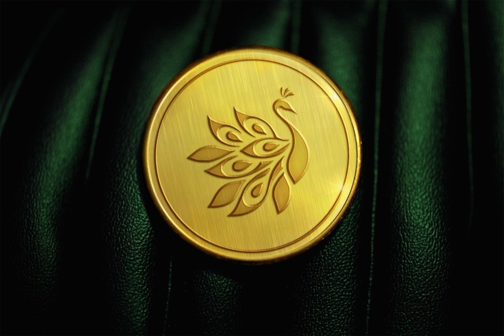 Custom engraved peacock motif on a 24K gold coin for corporate gifting in Nagpur